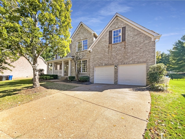 view of front of property featuring a front yard, a porch, and a garage