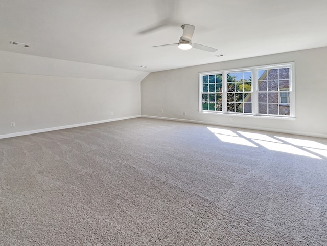 interior space with ceiling fan, carpet flooring, and vaulted ceiling