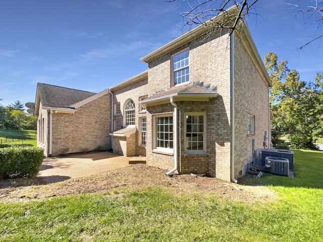 back of house with a yard, a patio, and central AC