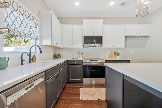 kitchen with dark wood-type flooring, sink, white cabinetry, gray cabinets, and appliances with stainless steel finishes