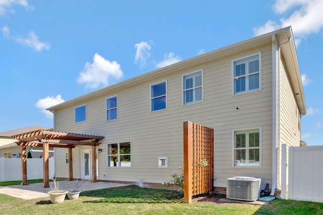 back of property with a pergola, a patio area, a lawn, and central AC unit