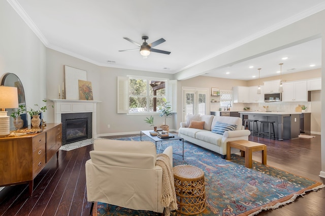 living room featuring dark wood-type flooring, crown molding, and ceiling fan