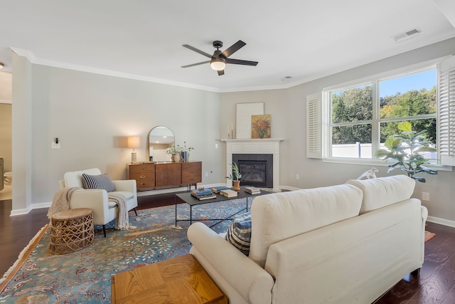 living room featuring dark wood-type flooring, crown molding, and ceiling fan