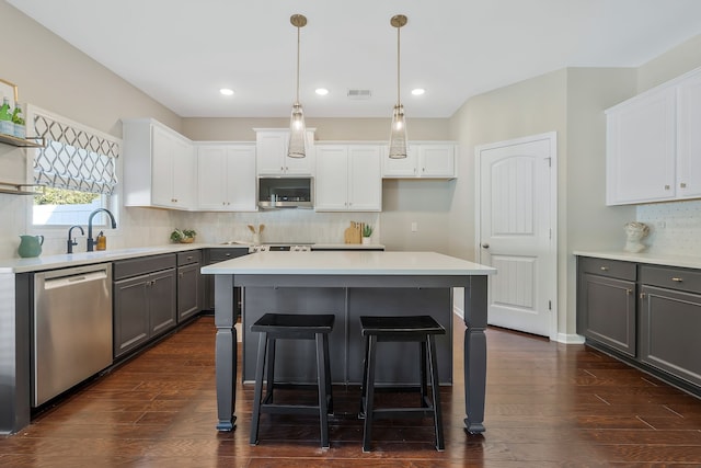 kitchen featuring white cabinetry, dark hardwood / wood-style floors, pendant lighting, gray cabinetry, and stainless steel appliances