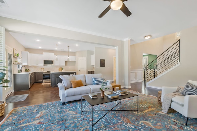 living room with sink, ceiling fan, crown molding, and dark hardwood / wood-style flooring