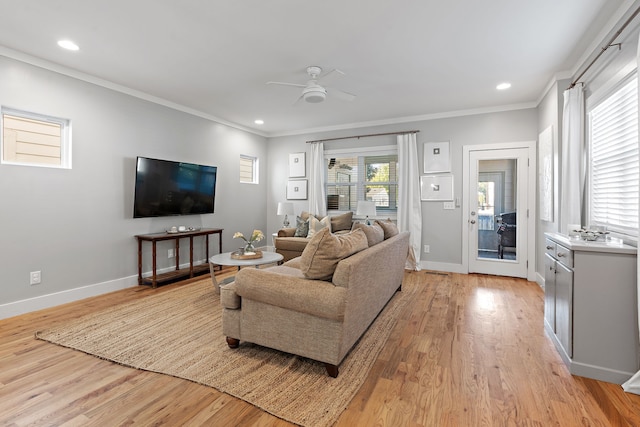 living room with ornamental molding, light hardwood / wood-style floors, and ceiling fan