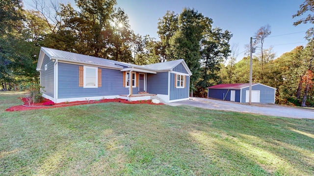 view of front of house featuring a front yard, an outbuilding, and a garage