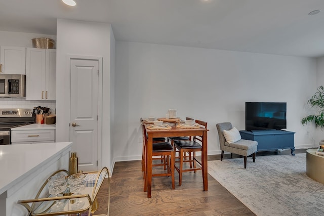 dining space with dark hardwood / wood-style flooring