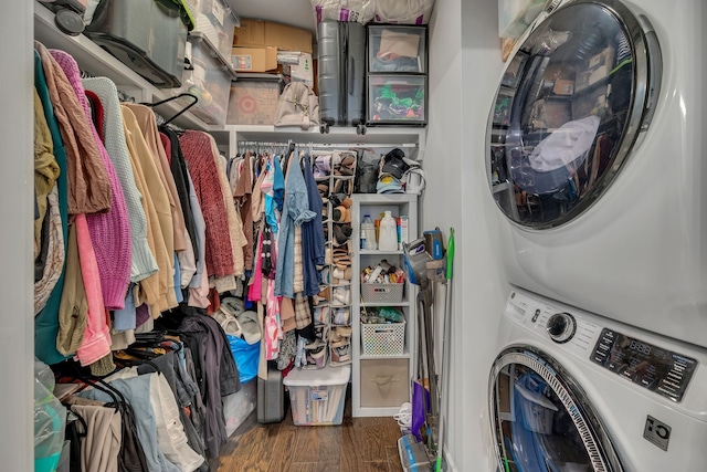 laundry area with stacked washer / dryer and dark wood-type flooring