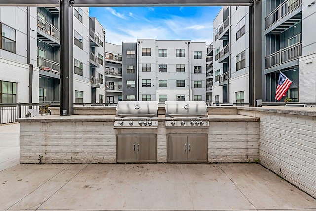 view of patio featuring an outdoor kitchen, a grill, and a balcony