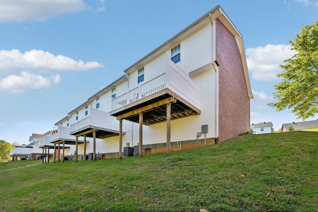 rear view of property featuring a lawn and cooling unit