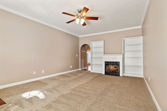 unfurnished living room with arched walkways, crown molding, carpet flooring, ceiling fan, and baseboards