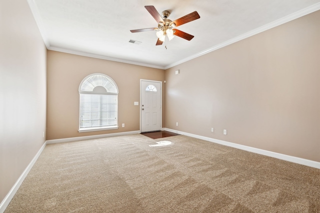 empty room with visible vents, baseboards, a ceiling fan, crown molding, and carpet flooring