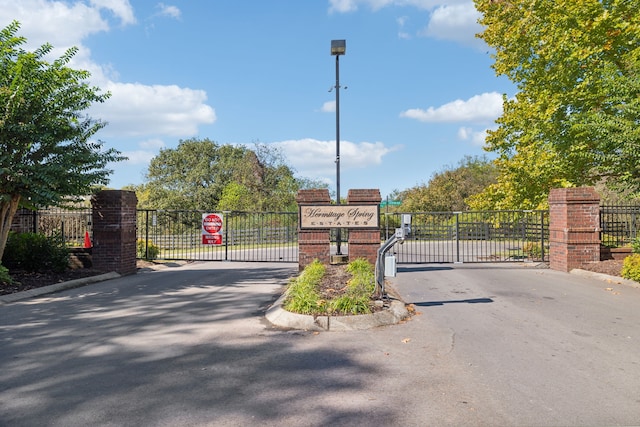 view of road with a gate, curbs, and a gated entry