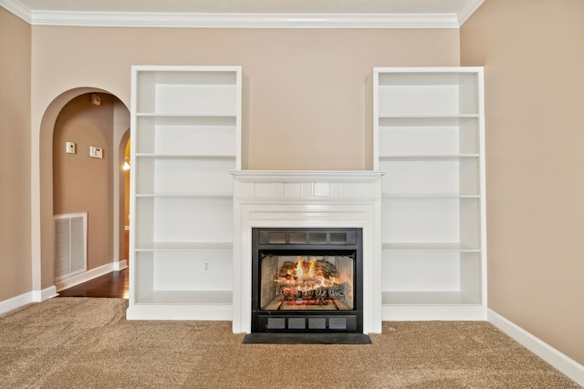 unfurnished living room featuring a warm lit fireplace, visible vents, baseboards, ornamental molding, and carpet