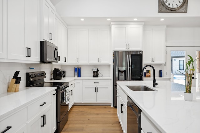 kitchen featuring white cabinetry, light hardwood / wood-style flooring, black appliances, and sink