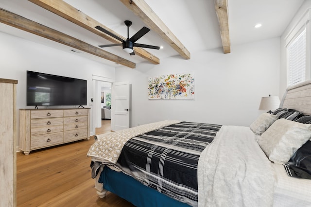 bedroom with ceiling fan, hardwood / wood-style flooring, and beam ceiling