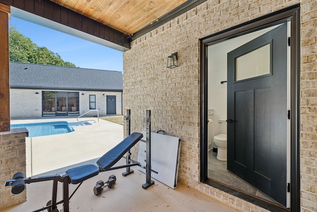 exterior space with brick wall and wood ceiling