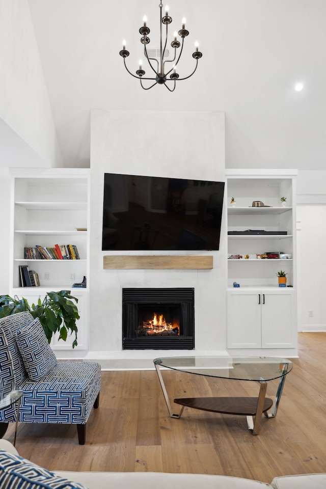 living room featuring light hardwood / wood-style flooring, a notable chandelier, and lofted ceiling