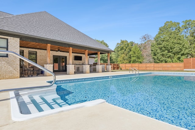 view of swimming pool with a patio, ceiling fan, and french doors