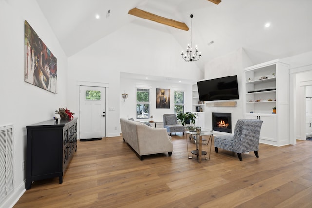 living room featuring light hardwood / wood-style floors, high vaulted ceiling, beam ceiling, and a chandelier