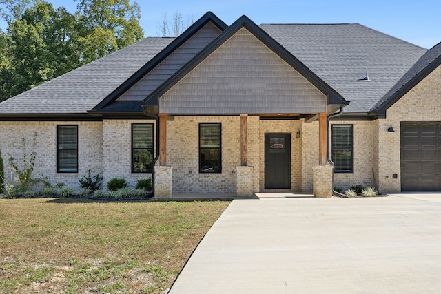 craftsman inspired home with a front yard, a garage, and a porch