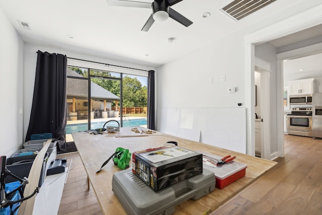 living room featuring light hardwood / wood-style flooring and ceiling fan