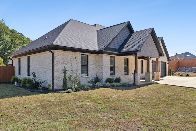 view of side of home with a patio and a lawn