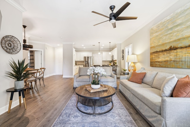 living room with dark wood-type flooring, crown molding, and ceiling fan