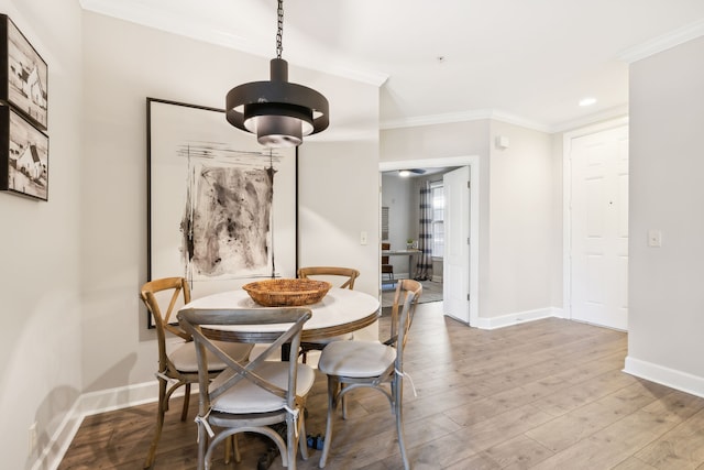 dining space with ornamental molding and hardwood / wood-style floors