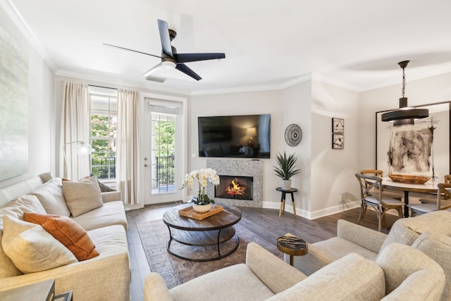 living room featuring crown molding, a fireplace, and dark hardwood / wood-style floors