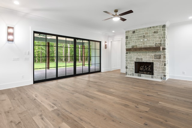 unfurnished living room featuring hardwood / wood-style floors, a fireplace, crown molding, and ceiling fan