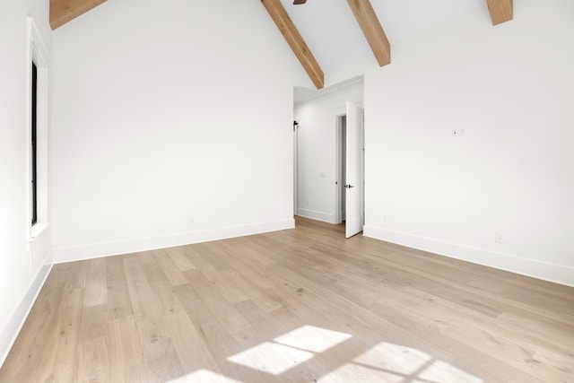 unfurnished room with beam ceiling, high vaulted ceiling, and light hardwood / wood-style flooring