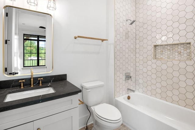 full bathroom with tiled shower / bath, vanity, and toilet