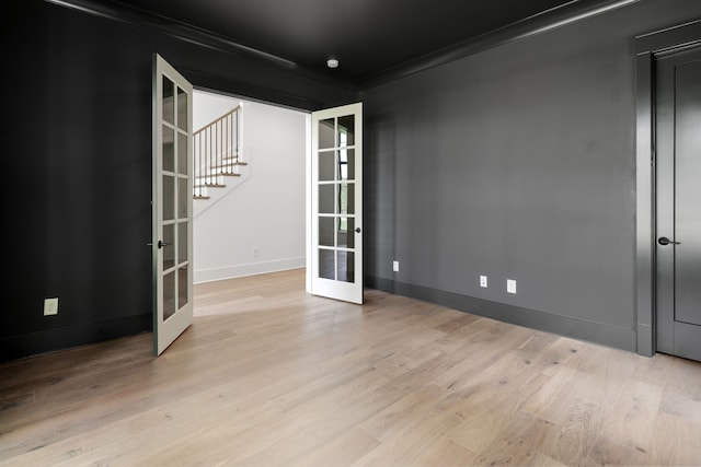 unfurnished room featuring light hardwood / wood-style floors, french doors, and ornamental molding