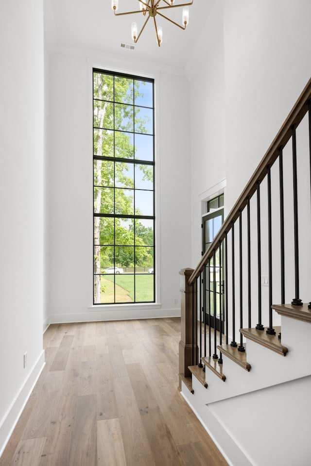 entrance foyer with crown molding, a notable chandelier, and light hardwood / wood-style floors