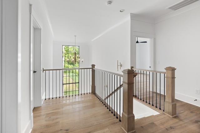 hallway featuring an inviting chandelier and light wood-type flooring