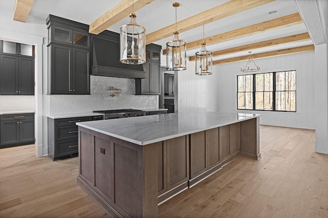 5104 Cobbler Ridge Ct, Franklin, TN 37064 - kitchen with premium range hood, light wood-style floors, stainless steel gas cooktop, beam ceiling, and a spacious island