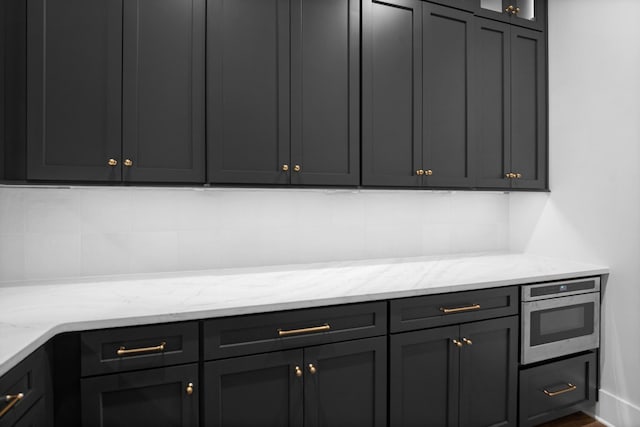 5104 Cobbler Ridge Ct, Franklin, TN 37064 - kitchen featuring light stone countertops, glass insert cabinets, and decorative backsplash