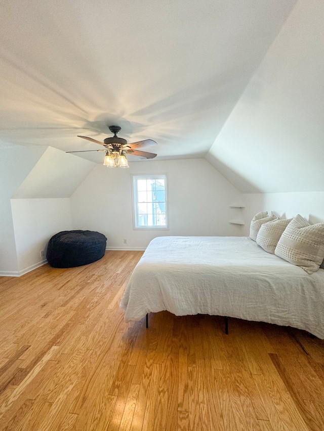 bedroom with ceiling fan, lofted ceiling, and light hardwood / wood-style floors