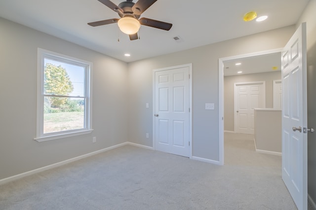 unfurnished bedroom featuring ceiling fan and light colored carpet