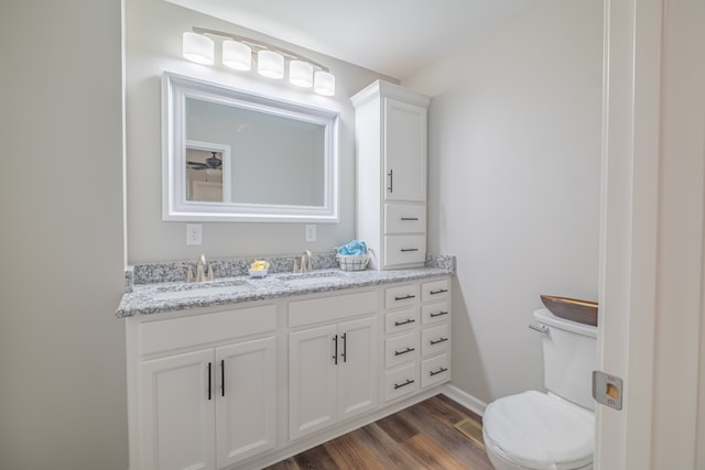 bathroom with toilet, vanity, and hardwood / wood-style flooring