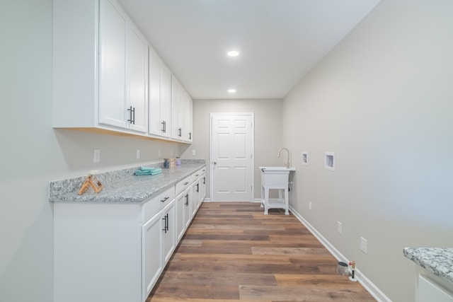 interior space featuring sink, dark wood-type flooring, hookup for a washing machine, and cabinets