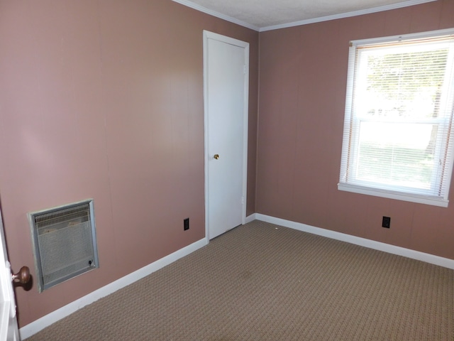 carpeted empty room with crown molding and heating unit