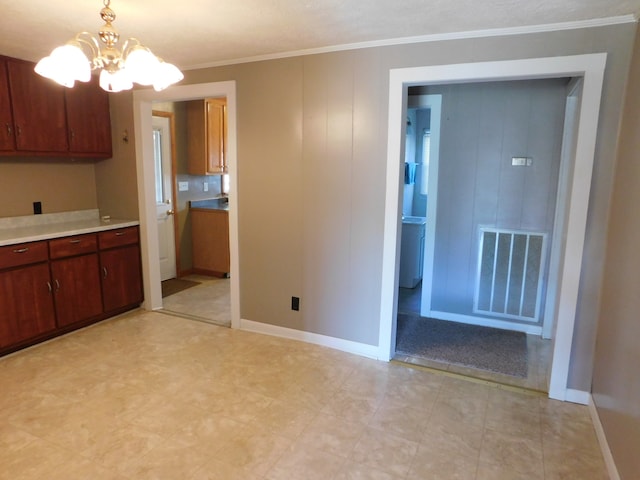 kitchen featuring an inviting chandelier, ornamental molding, and decorative light fixtures