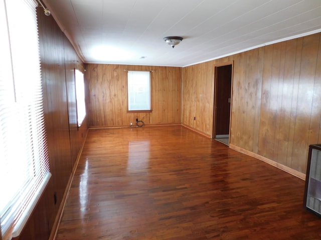 empty room with wood walls and dark hardwood / wood-style flooring