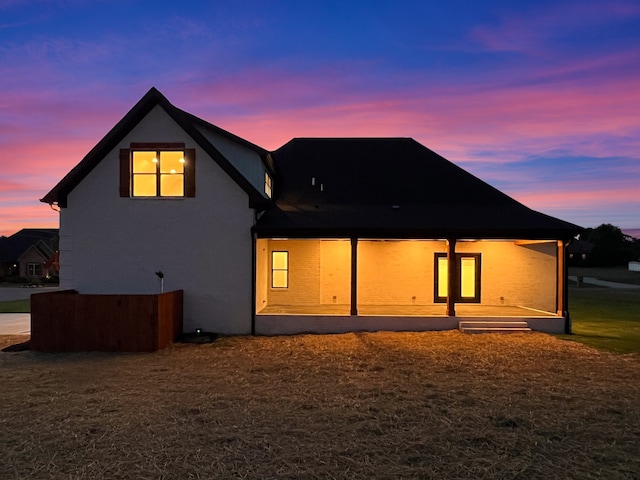 back house at dusk featuring a yard