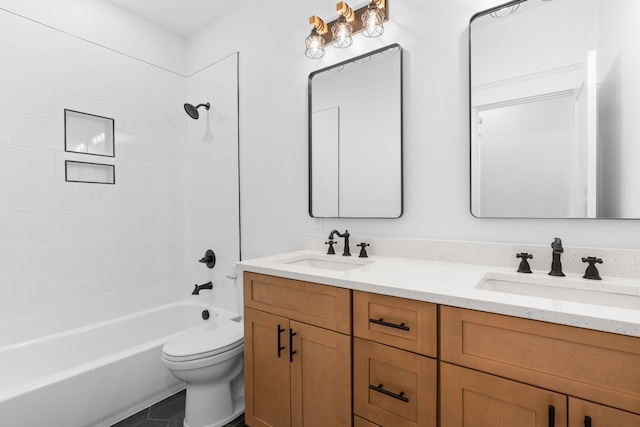 full bathroom featuring vanity, tiled shower / bath combo, and toilet