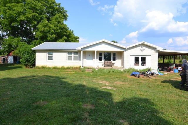 rear view of house featuring a lawn and a carport