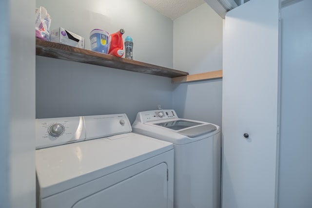 laundry room featuring washing machine and dryer and a textured ceiling